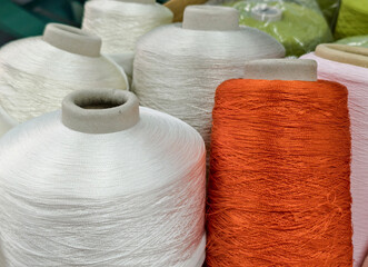 textile industry concept, bobbins of synthetic yarn in different colors