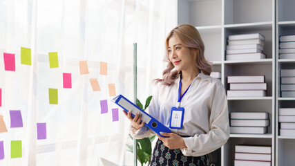 Smart office woman holding multiple folders while managing documents in organized workspace