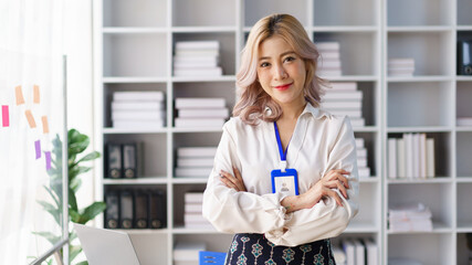 Confident businesswoman standing with arms crossed in office showing leadership and professionalism