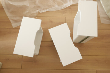 White furniture pieces arranged on a wooden floor in a bright room