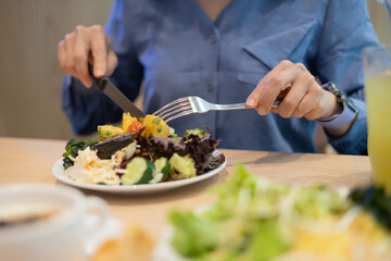 woman is eating a salad at a dining table in a restaurant