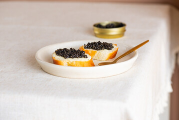Natural black caviar and butter on a toasts on a table. Sturgeon caviar.