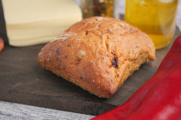 Freshly baked bread with cheese and vegetables on wooden board