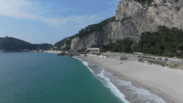 sideways low hover from beach to sea at the Spiaggia del Malpasso beach near the roadway in northwestern Italy