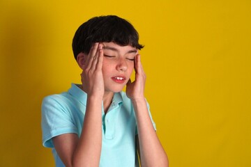 preteen boy with headache. boy with his hands on his temples and gesture of pain or discomfort