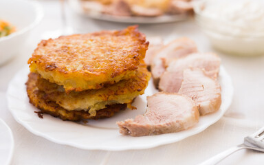 Potato pancakes with meat on white plate