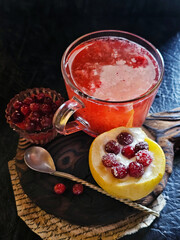 Baked apple with cottage cheese and lingonberries and fruit drink on a black background