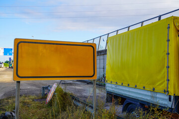 Empty road sign and delivery truck with tarpaulin on highway construction site, perfect for adding...