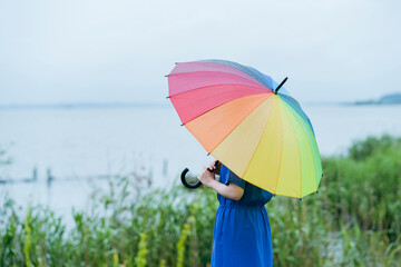 雨の中、カラフルな傘を指す女性