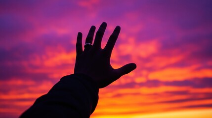 Hand Reaching Towards Vibrant Sunset Sky