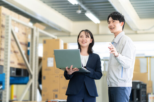 倉庫で打ち合わせをする若いビジネスマン
 - Powered by Adobe