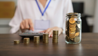 Tax concept, businesswoman and stacked coins in a glass.