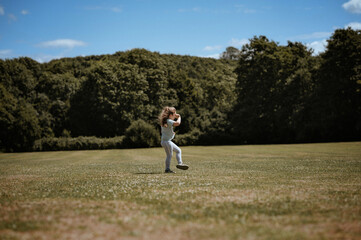 A girl stays on the football field. she watching the game.