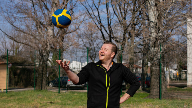Man playing volleyball outdoors on a sunny day, focused and in motion.