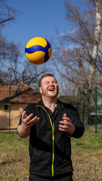 Man playing volleyball outdoors on a sunny day, focused and in motion