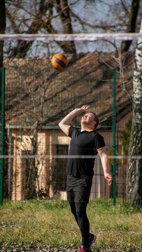 Man playing volleyball outdoors on a sunny day, focused and in motion