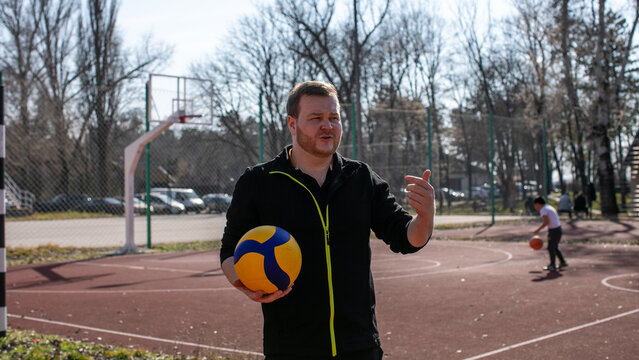 Man playing volleyball outdoors on a sunny day, focused and in motion