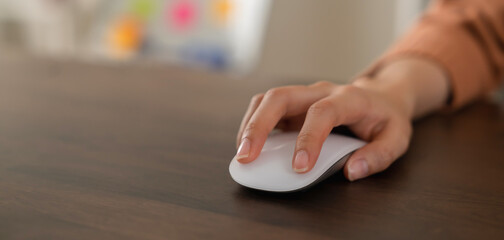 Close up of hand press the button computer mouse on table.