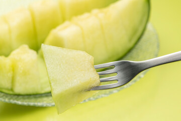 一口サイズにカットしたメロンをフォークで食べる