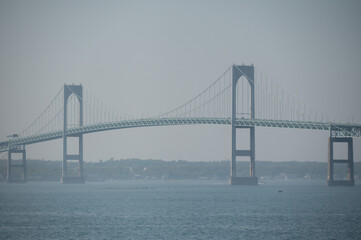 Suspension bridge stretches across water on a hazy coastal day