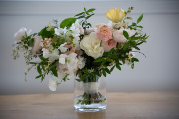 Elegant mixed bouquet in soft tones displayed in glass vase