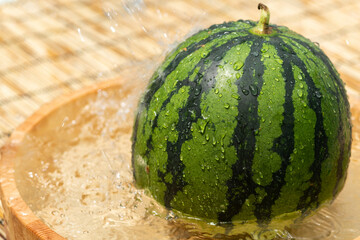 桶で冷やすスイカ © TAGSTOCK2