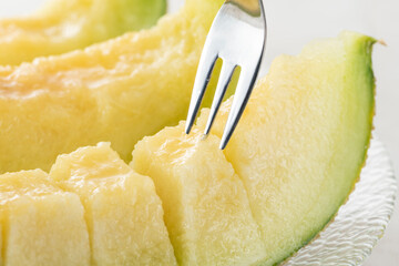 完熟したメロンをフォークで食べる