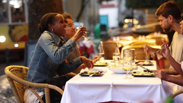 Friends enjoying dinner and drinks at outdoor restaurant