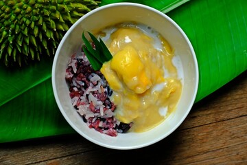 Sweet black and white sticky rice with durian in coconut milk. Thai popular dessert.