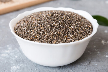 Chia seeds in bowl on colored background. Healthy Salvia hispanica in small bowl. Healthy superfood