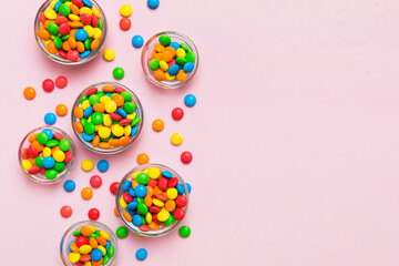 different colored round candy in bowl and jars. Top view of large variety sweets and candies with copy space