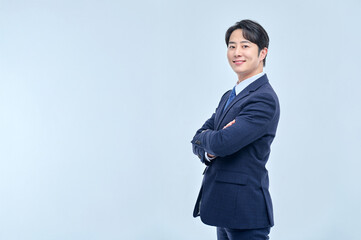 A young and confident man in a suit is striking a confident pose.