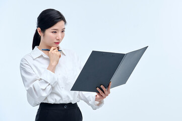 A beautiful Asian woman wearing a white shirt holds a file and a pen, lost in thought.