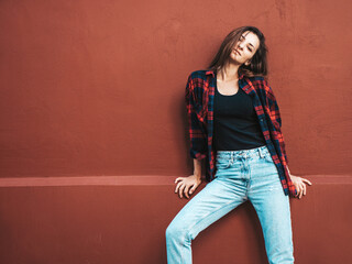 Portrait of beautiful smiling model. Female dressed in summer hipster checkered shirt and jeans....
