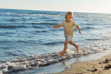 Happy child running and playing on the beach during summer vacation