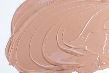 Liquid cosmetic texture of foundation, liquid powder in beige tone. waves of cosmetic texture. Abstract cosmetic background for product advertising.