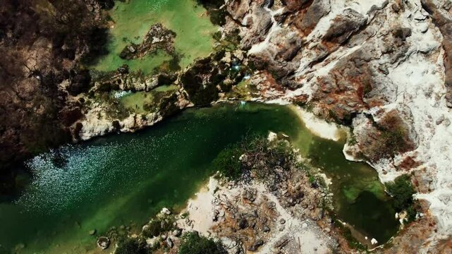 Aerial view of Wadi Darbat, Oman! A picturesque valley with waterfalls and lush greenery during Khareef season. Watch now!