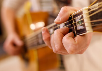 A guitar player is holding a guitar and playing a chord