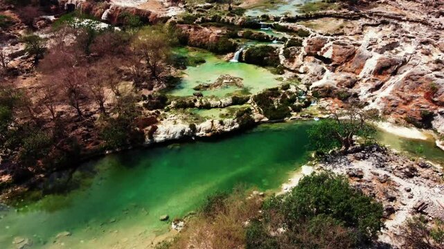 Aerial view of Wadi Darbat, a picturesque valley near Salalah, Oman. Lush greenery and waterfalls await! Watch now!