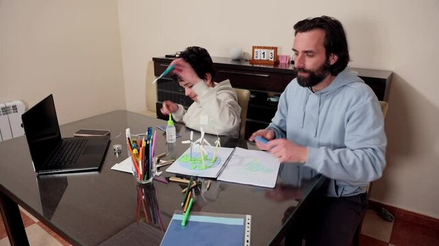 Father and Teenager Son Engaged in Educational and Creative Activities Together