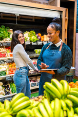 Saleswoman showing tablet to customer in organic supermarket