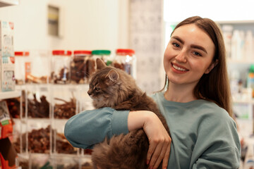 Woman with her cute cat in pet shop. Space for text