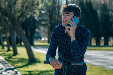 Teenager with an Electric Scooter using his smart phone