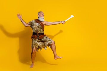 Full length photo of strong funny cave human wear leoprad skin fighting animal bone emtpy space isolated yellow color background