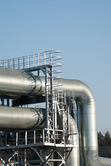 pipeline and metal ladder close-up against blue sky