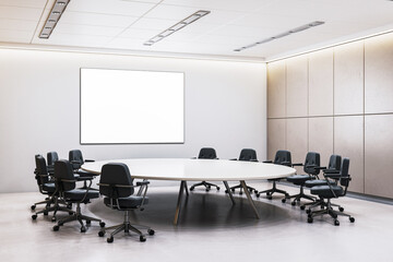 Modern corporate office interior with round table, ergonomic chairs, and blank poster frame on wall...