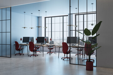 Modern office interior with open workspace, red chairs, desks with computers, glass partitions, and...