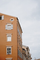 Elegant Orange Window with White Shutters Framed by a Simple Wall