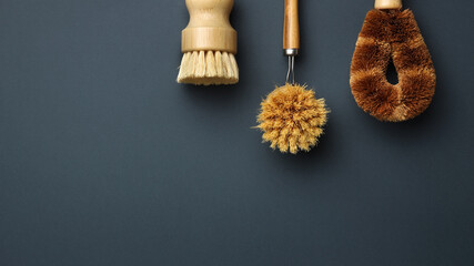 Eco friendly cleaning brushes for washing dishes close-up on grey background. Flat lay eco cleaning products. Cleaner concept.