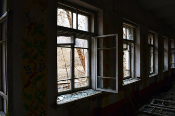 Fototapeta premium open window with old wooden frame. old window. finely broken glass. old house, retro. cracked window frame. cracked old paint, pieces of glass. space for text. large pieces of glass. horror, war